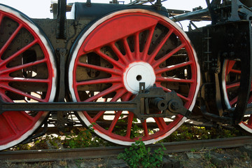 large steel wheels of old steam locomotive red with white outline
