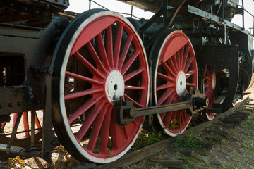 Fototapeta na wymiar large steel wheels of old steam locomotive red with white outline