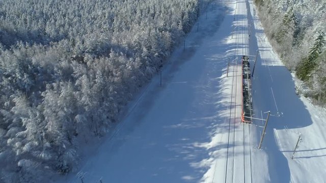 Aerial view of passenger train driving on railway in winter