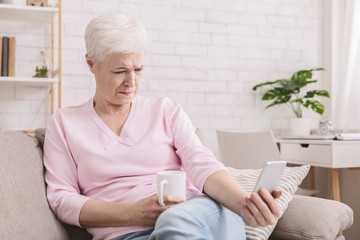 Senior woman with vision problems using phone