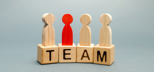 Wooden blocks with the word Team and a crowd of workers with a leader. The concept of a strong reliable business team. Teamwork. Team management. Choosing a new mentor. Wooden figures of people