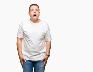 Fototapeta premium Middle age arab man wearig white t-shirt over isolated background afraid and shocked with surprise expression, fear and excited face.