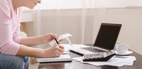 Senior woman bookkeeping bills and payments at home