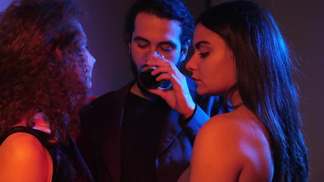 polygamy, love triangle, polyamory. Three young people flirting in the dark