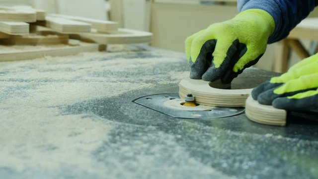 Locksmith removes a chamfer with a radius cutter at a furniture factory. Manufacture of wooden furniture