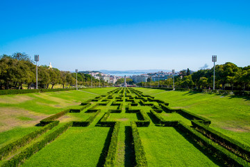 View of the labyrinth of Eduardo VII park and gardens, the largest park in the center of Lisbon and Tagus river in the background, in Lisbon, Portugal