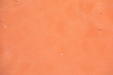 Bright rich texture of peach color. Cement a background of a weather-beaten wall with the cracked structure
