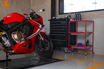 closeup sport motorcycle in repair station and body shop with soft-focus and over light in the...