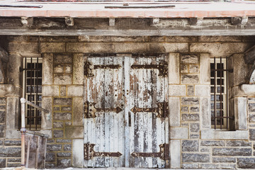 Worn door with peeling paint on abandoned stone building