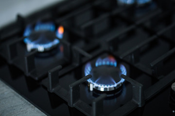 Cooktop with burning gas rings. Gas cooker with blue flames.