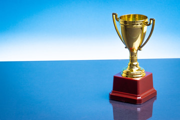 Trophy on the blue background. Selective focus