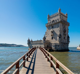 Fototapeta premium Scenic Belem Tower and wooden bridge miroring with low tides on Tagus River. Torre de Belem is Unesco Heritage and icon of Lisbon and the most visited attraction in Lisbon, Belem District, Portugal