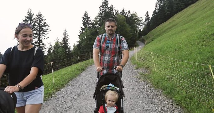 Man and woman with prams go outdoors in summer.