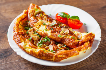 omelette with bacon in a white plate on wooden table