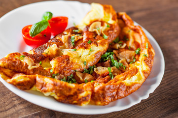 omelette with bacon in a white plate on wooden table