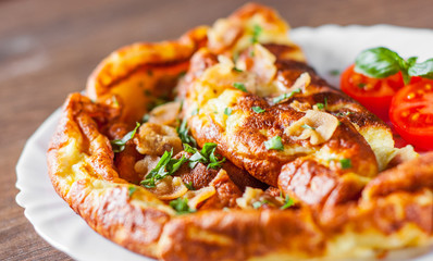 omelette with bacon in a white plate on wooden table