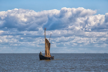 Retro wooden sailing ship sails into the sea.