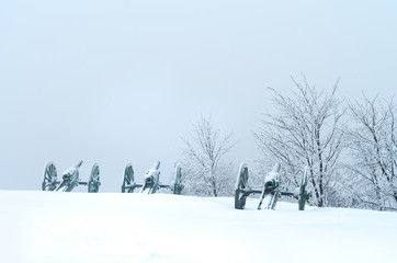 Old metal cannons covered with snow