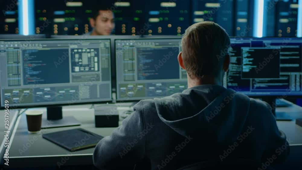 Fototapete IT Specialist Works on Personal Computer with Screens Showing Software Program with Coding Language Interface. In the Background Technical Room of Data Center with Professional Working
