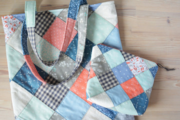 Quilted tote bag and notion pouch on the wooden table	
