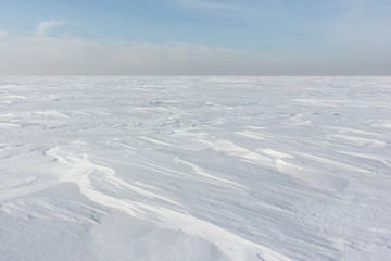 Fototapeta na wymiar Snow on a frozen river in winter, Ob Reservoir, Novosibirsk, Russia