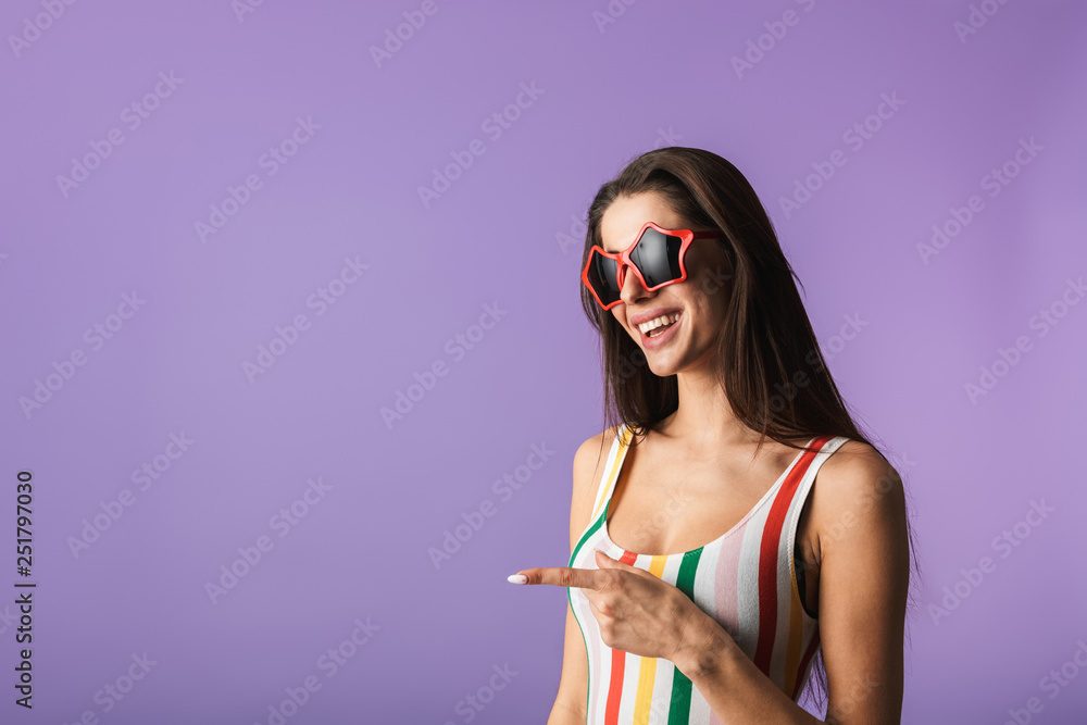 Wall mural cheerful young girl wearing swimsuit standing