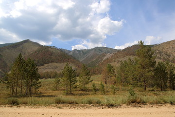The forest and the mountains with gravel roads View of the foothills of the Barguzin range with areas of steppe and forest from the road with gravel