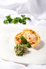 Quiche with chicken, tomatoes and greens on a white background