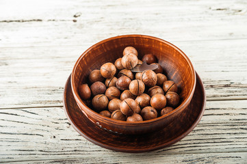 Macedonian nuts on a wooden plate on the background of a textural wooden table. Macedonian nuts...