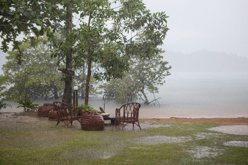 Fototapeta na wymiar Tropical rain on the beach in the recreation area by the sea