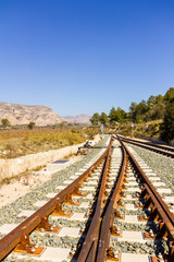 Fototapeta premium A railroad switch track with traffic signs, mountains and trees in the background