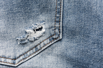 Denim blue jeans texture with scuffs and holes. Abstract background.