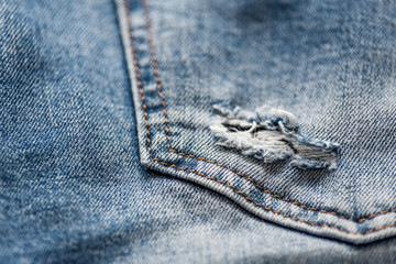 Denim blue jeans texture with scuffs and holes. Abstract background.