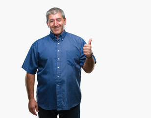 Fototapeta premium Handsome senior man over isolated background doing happy thumbs up gesture with hand. Approving expression looking at the camera with showing success.