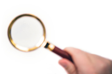 Blurred hand with magnifier on white background