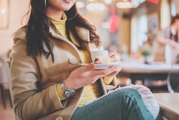 girl holding cup of coffee in coffee bar.