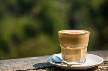 Fototapeta na wymiar Cup of coffee latte on wood bar In the coffee shop