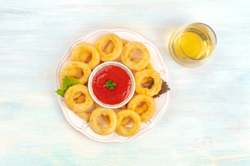 A plate of squid rings, shot from the top with a dip, a glass of wine, and copy space