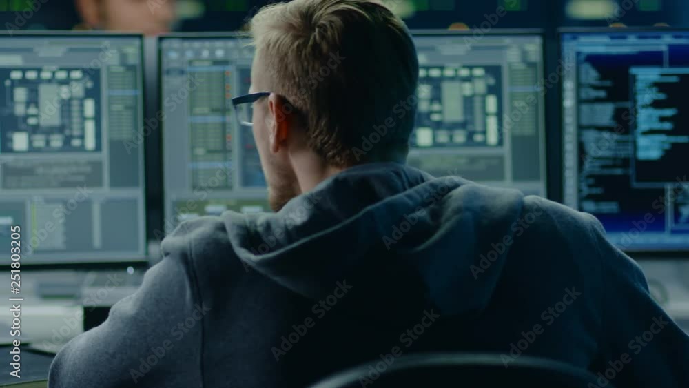 Poster IT Specialist Working on Personal Computer with Screens Showing Software Program with Coding Language Interface. In the Background Technical Room of Data Center