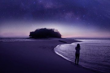 The girl standing on the beach with beautiful million stars galaxy
