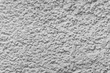 Black and white whitewashed concrete wall interspersed with stones