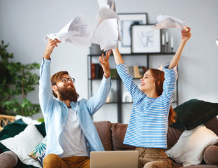 married couple with bills receipts documents and laptop at home.