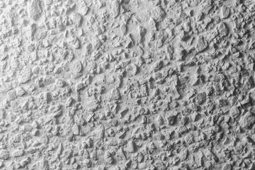 Black and white whitewashed concrete wall interspersed with stones