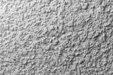 Black and white whitewashed concrete wall interspersed with stones