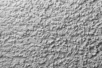 Black and white whitewashed concrete wall interspersed with stones