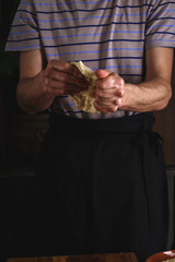 A man kneads dough with his hands