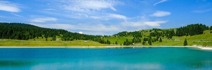 Panorama, landscape of a  turquoise lake in Italy. Passo Coe Lake, Folgaria, Trento, Trentino, Italy - August 2018