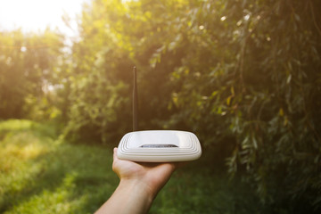 Man is looking for wi-fi signal in the nature. Guy is lost and holding router in his hands...