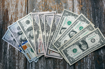 Dollar banknotes are lying on the natural vintage background. Money notes on the wooden  surface....