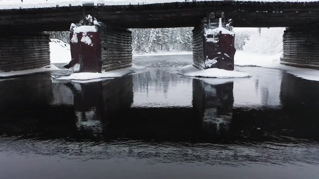 Aerial  flight under  wooden Bridge above winter river, Northern Karelia Province, Paanaj&auml;rvi , Russia, Olanda river